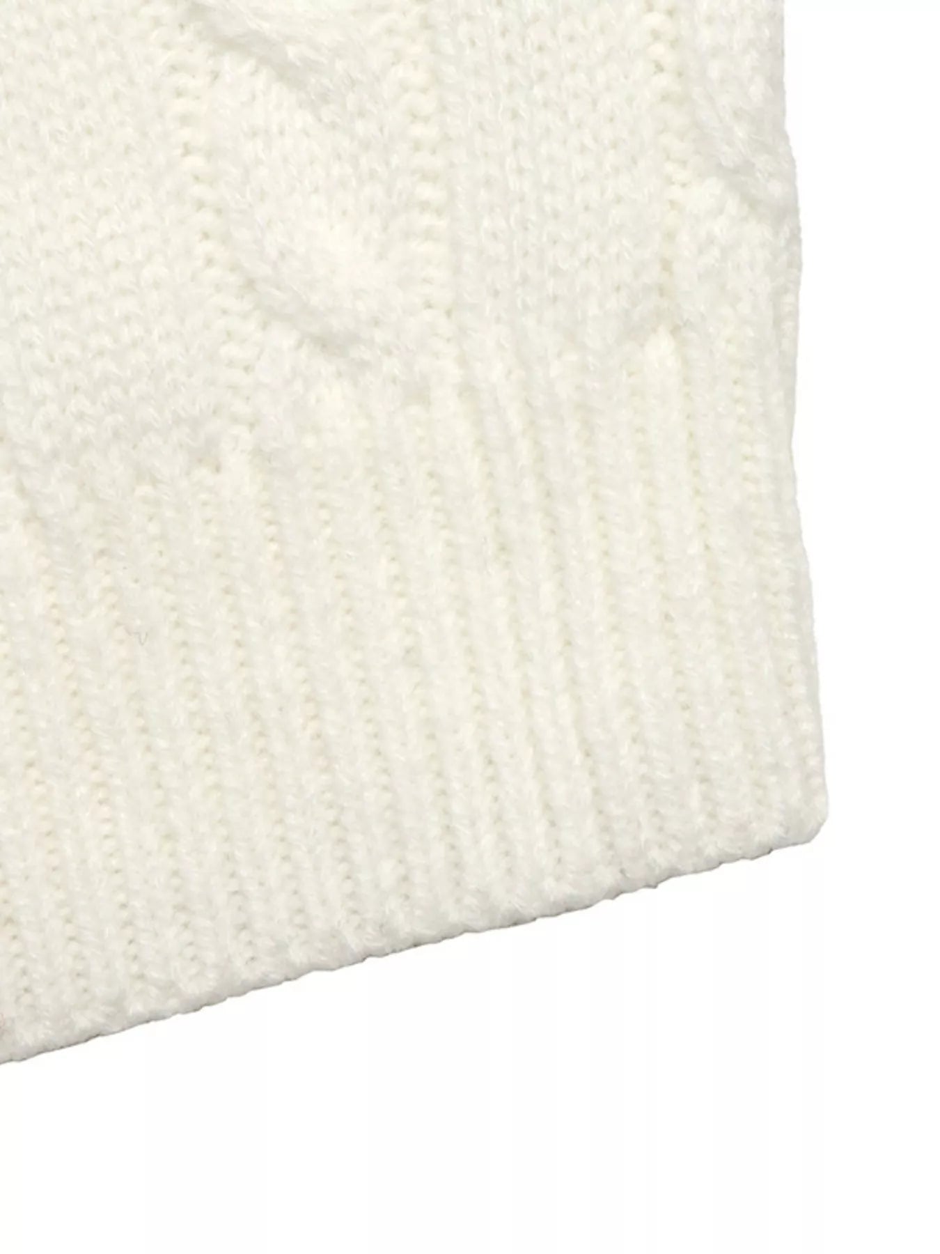 Close up of ribbed hem on white cable knit sweater showing knit texture