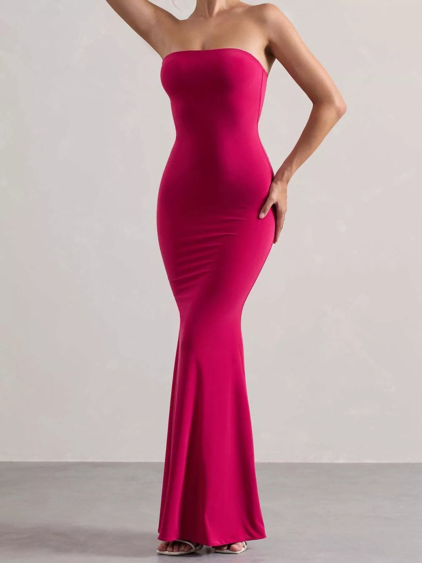 Model wearing strapless rose red tube maxi dress, three quarter front view in studio