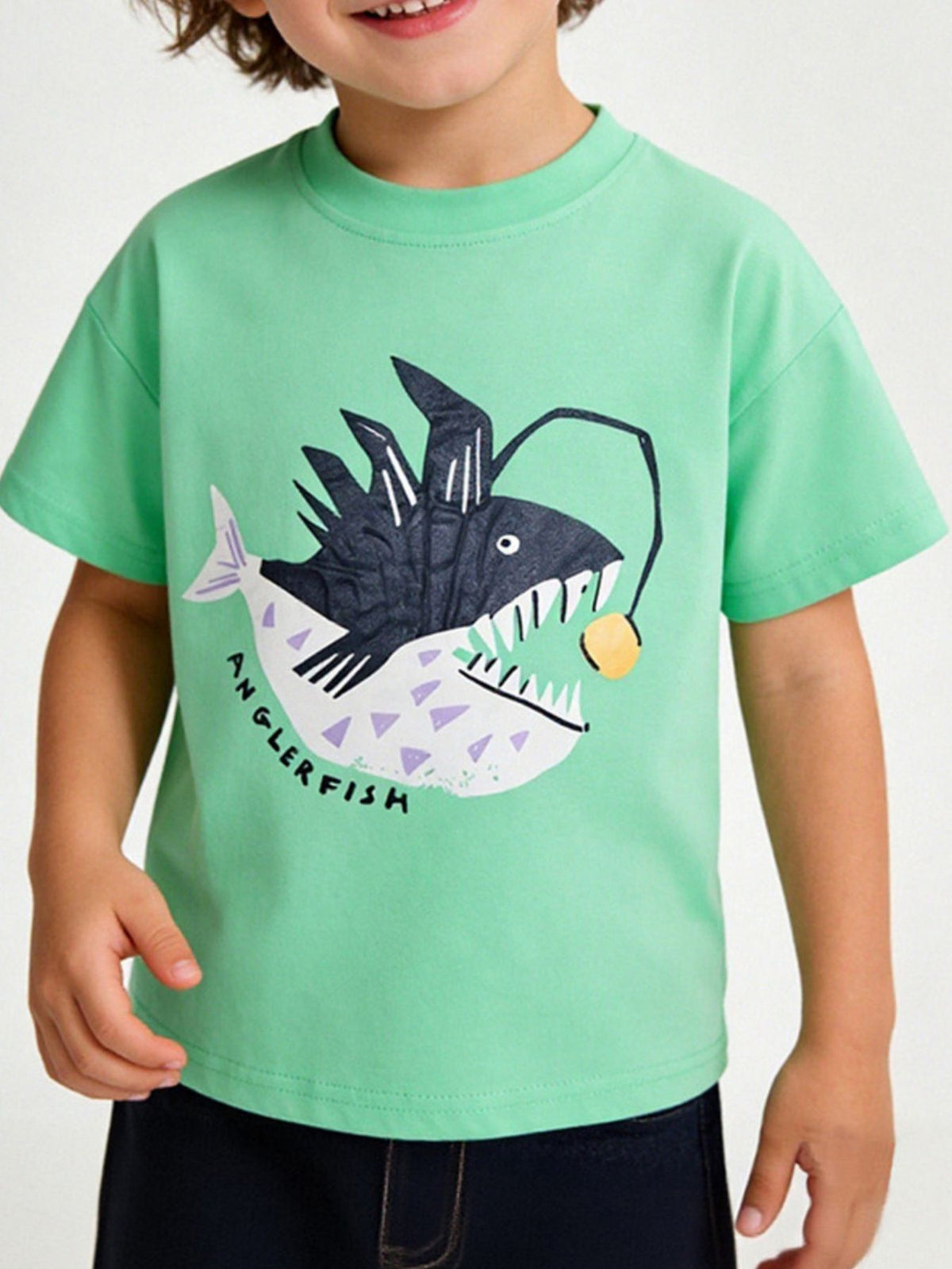 Children's neon green t-shirt worn in front view with large anglerfish graphic and glowing lure