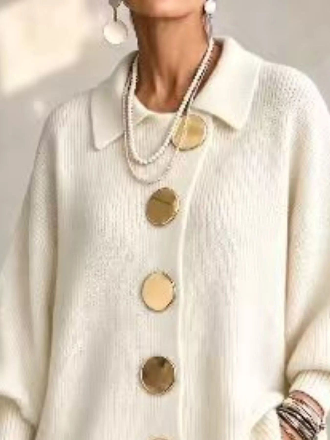 Close up of the cream cardigan collar and large gold front buttons