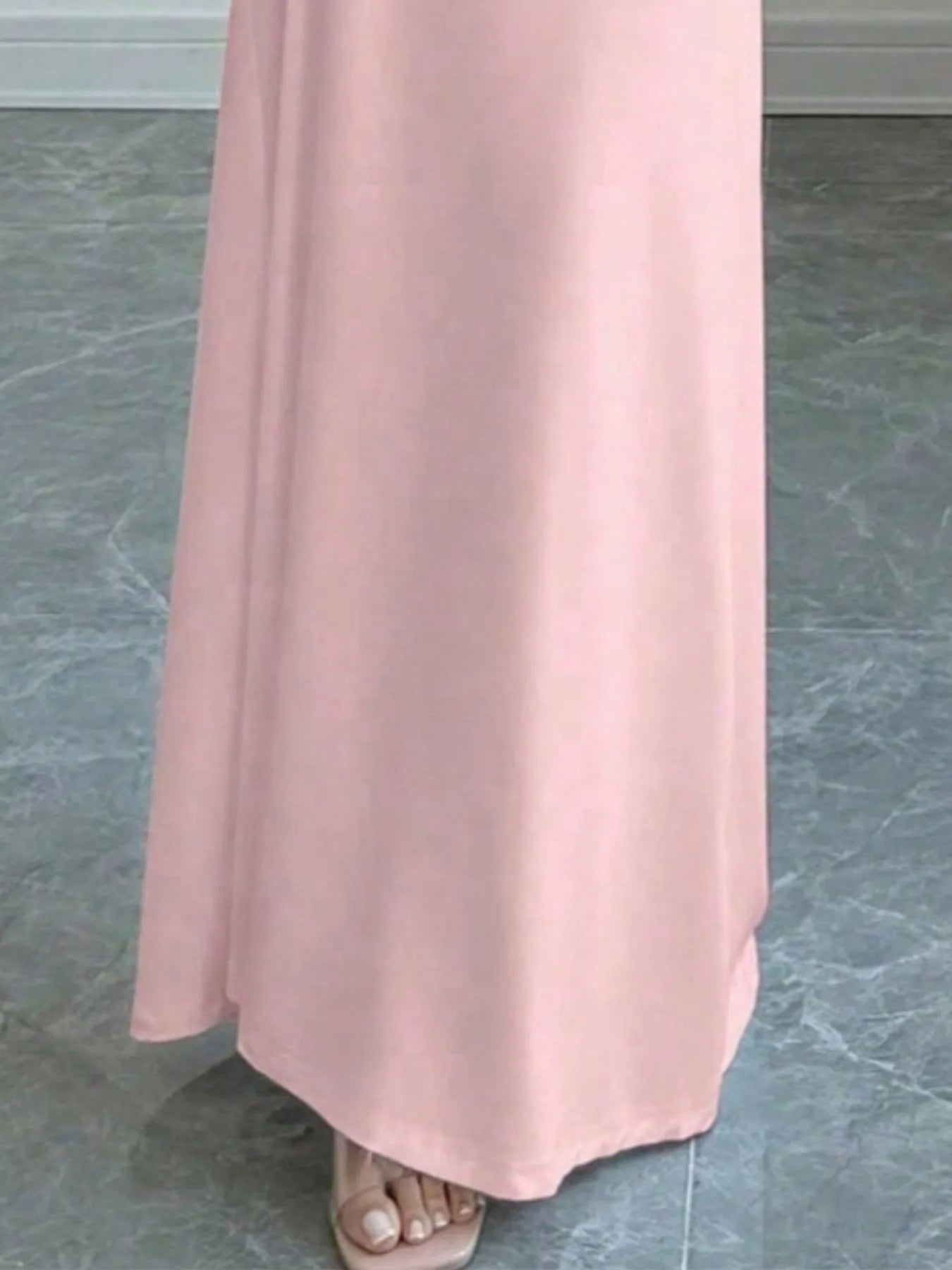 Close view of pink off shoulder maxi skirt hem and floor length fabric