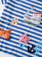 Close up of the nautical appliques on a children's blue and white striped short sleeve tee