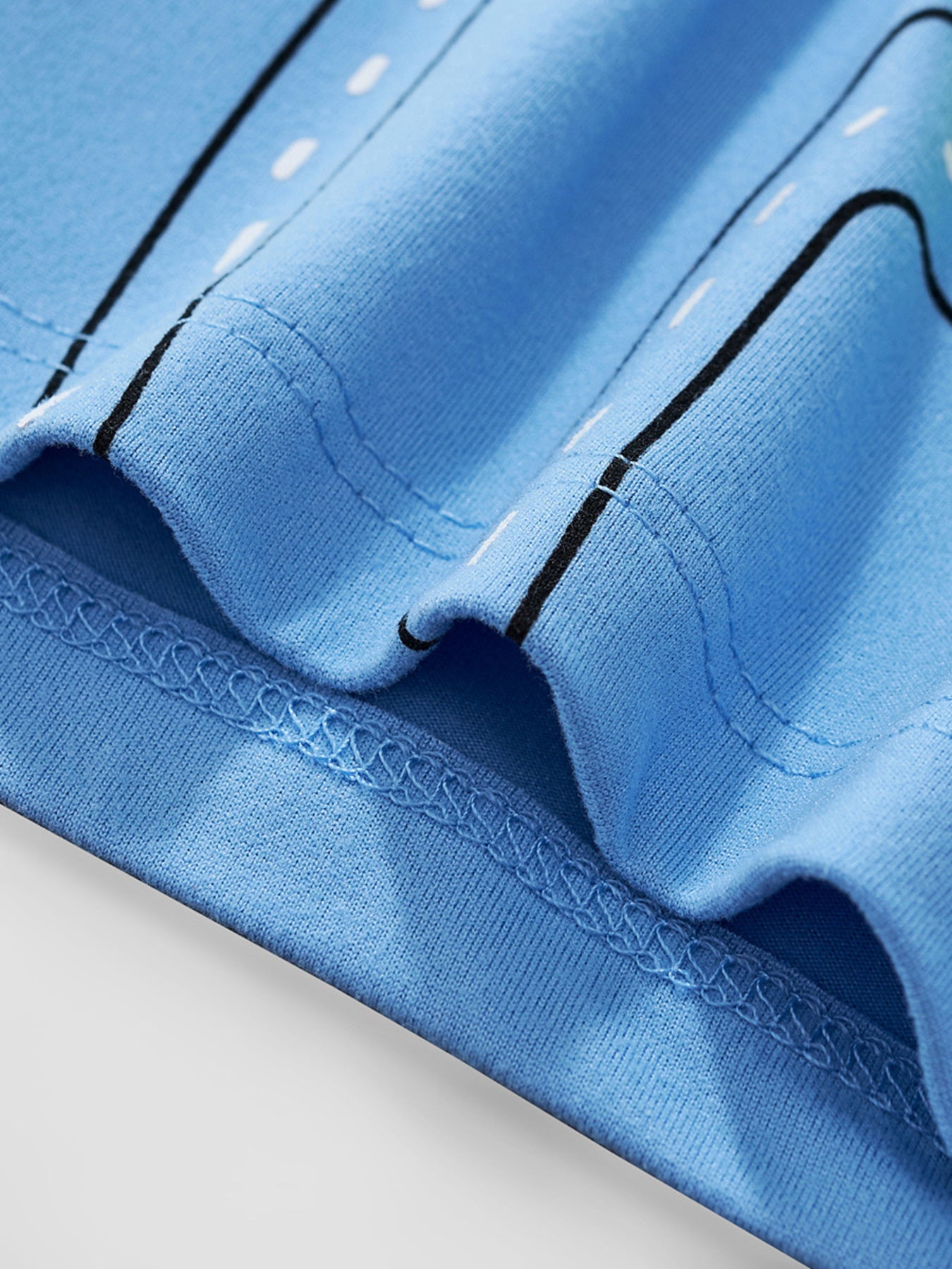 Close view of the hem stitching and printed road detail on the sky blue children's t-shirt