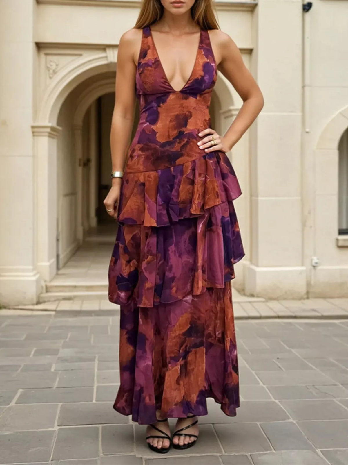 Front view of a deep purple floral V neck maxi dress with layered ruffles on a model outdoors