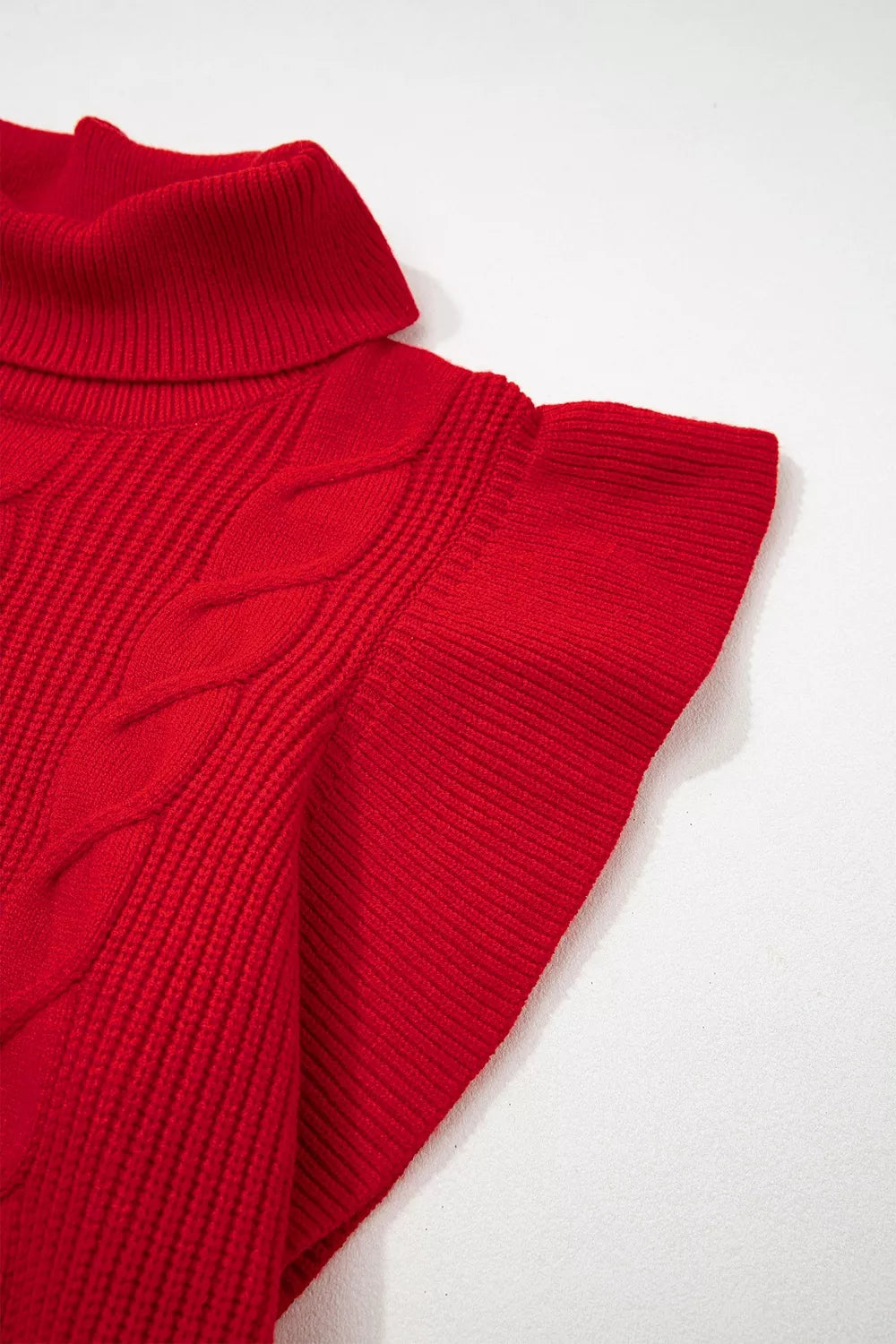 Close-up of the red cable knit turtleneck sweater ruffled short sleeve