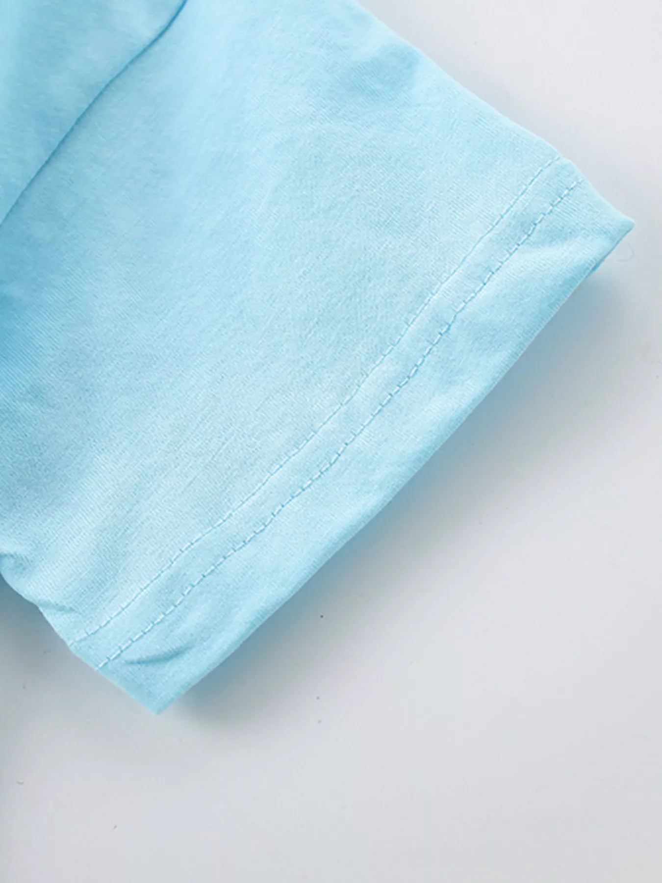 Close-up of the pastel blue short sleeve hem with double stitching
