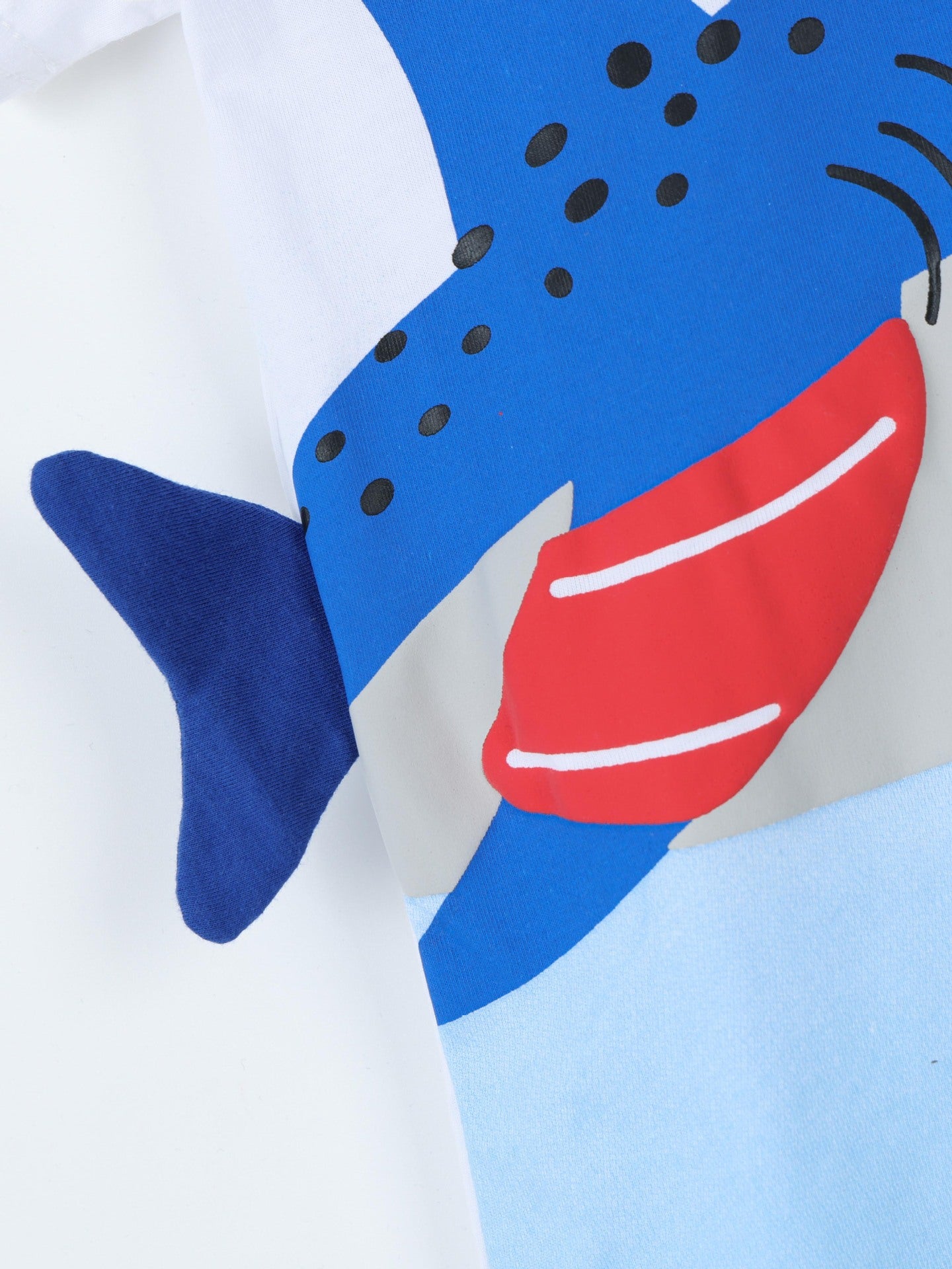 Close-up side detail showing the blue shark tail fin and red fin print on children's T-shirt