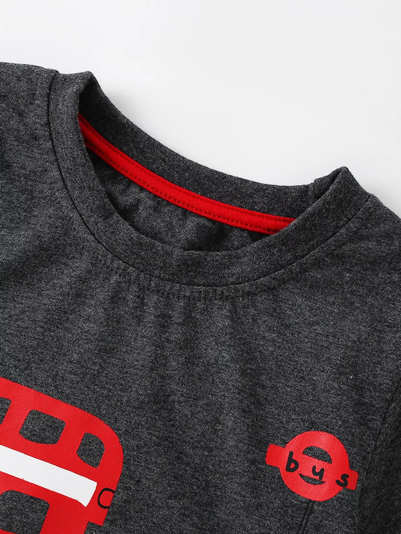 Close up of dark gray children's t-shirt round neckline with red inner trim stitching