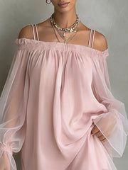 Close front view of a dusty pink off shoulder dress showing the smocked neckline and sheer sleeves