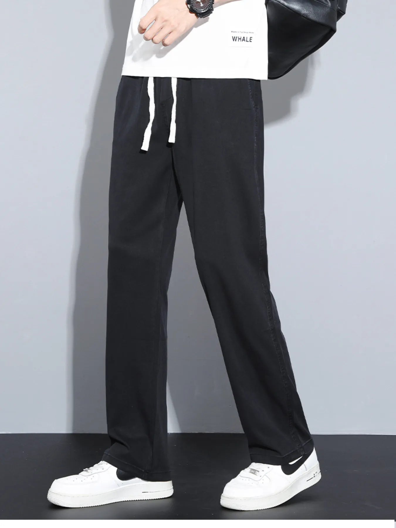 Men's black casual pants with wide legs and a drawstring waist.