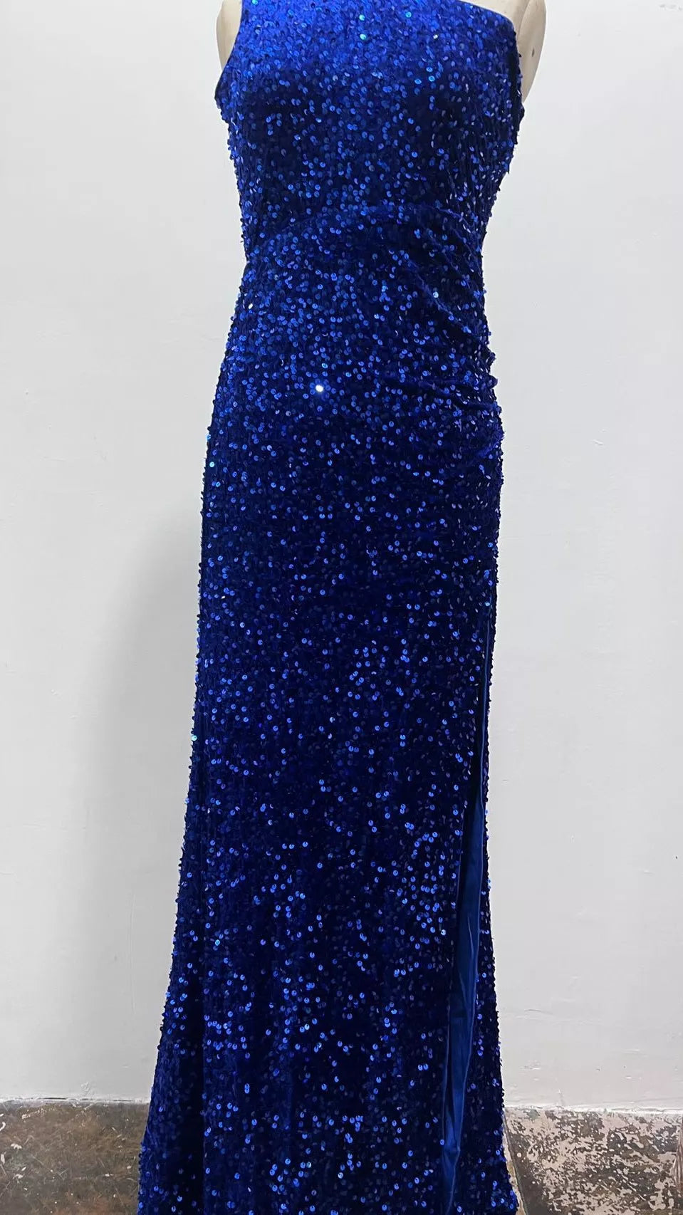 Royal blue sequin one shoulder evening dress shown in a full side view on a dress form