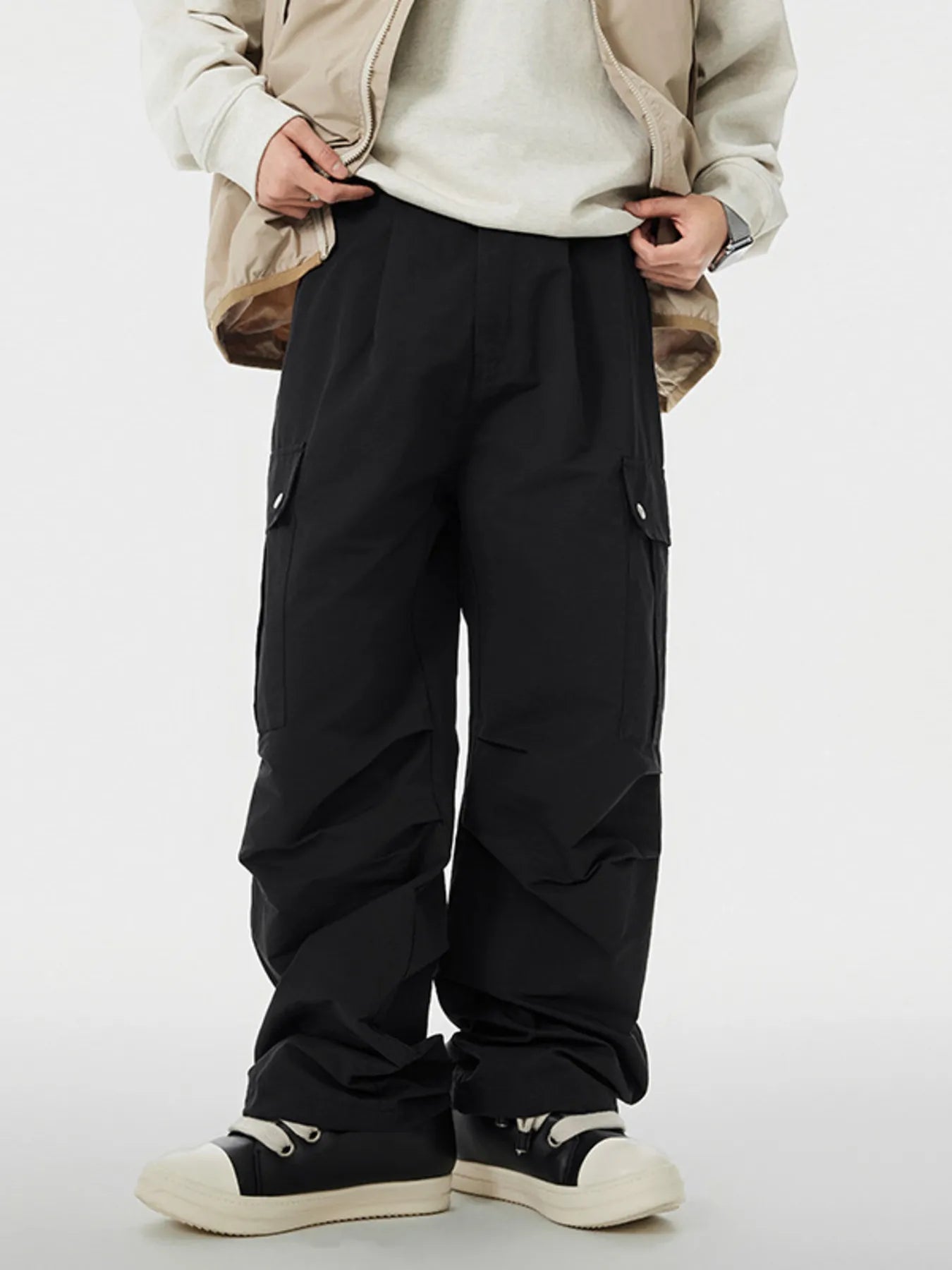 Men's black cargo pants with wide legs and pockets.