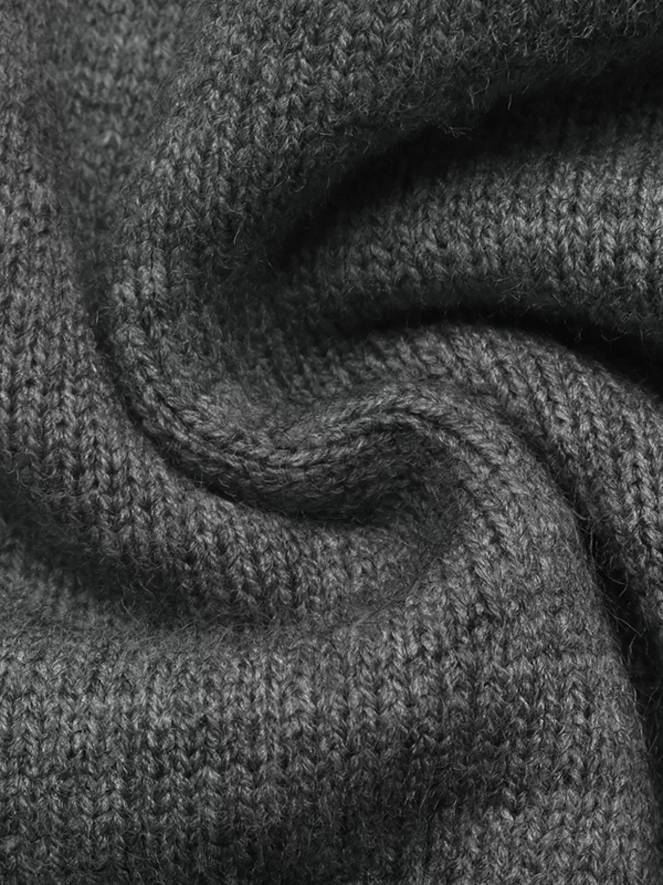 Close up of dark grey knit fabric showing soft texture and stitch detail