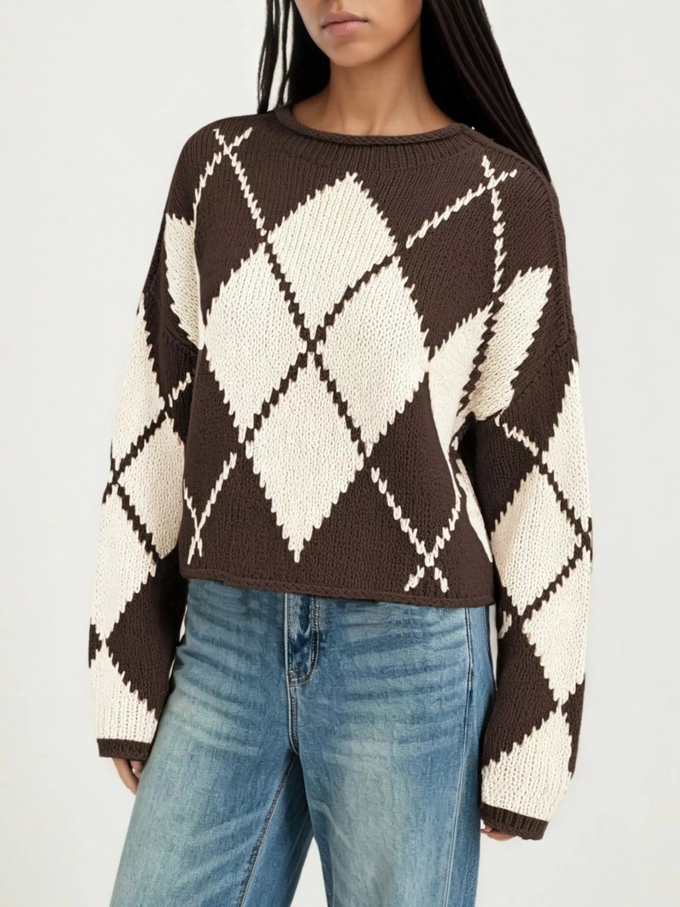On-model front view of a brown and cream argyle knit sweater with dropped shoulders