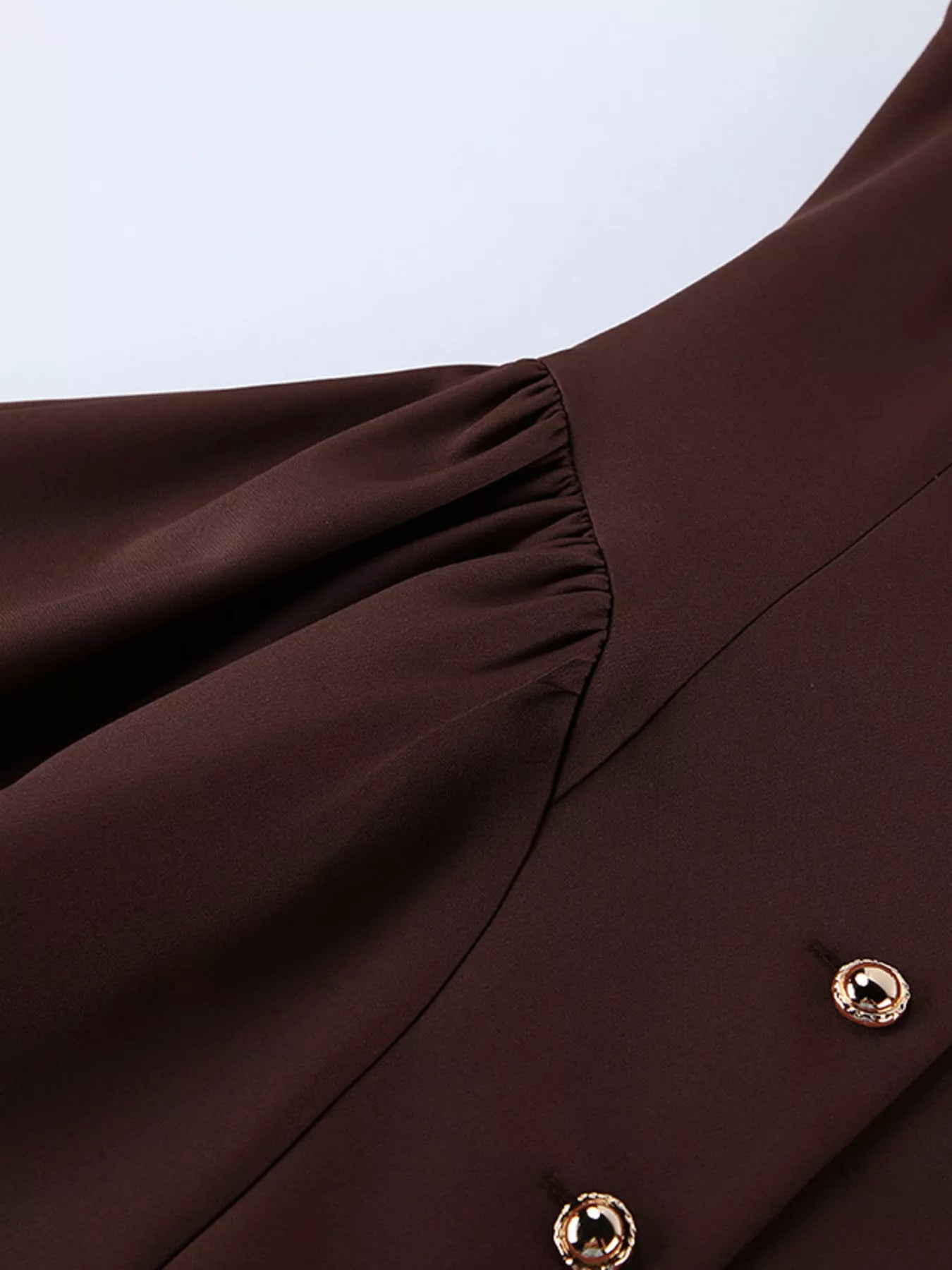 Brown button down mini dress detail showing gathered waist seam and gold button