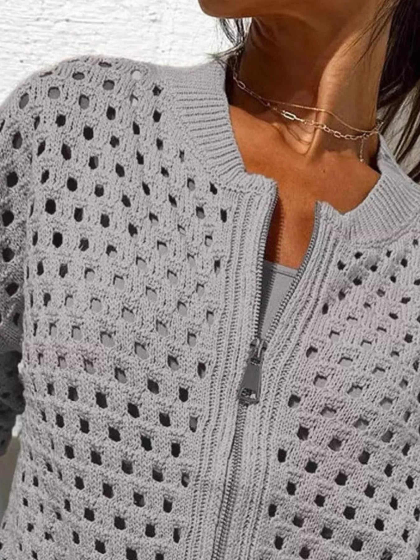Close up of the light gray crochet cardigan upper zip and openwork pattern