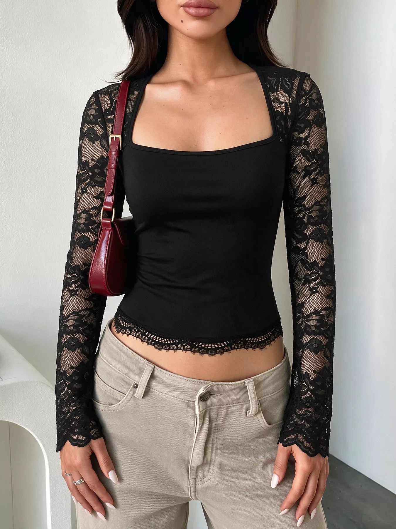 Black square-neck top with sheer floral lace long sleeves and a scalloped lace-trimmed hem.