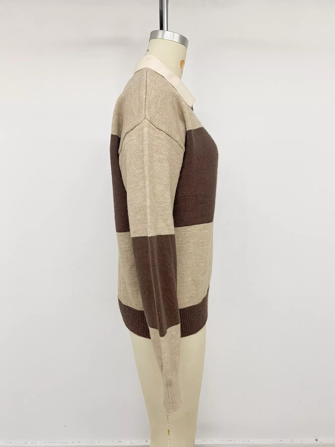 Side view of beige and brown color block polo sweater on a mannequin.