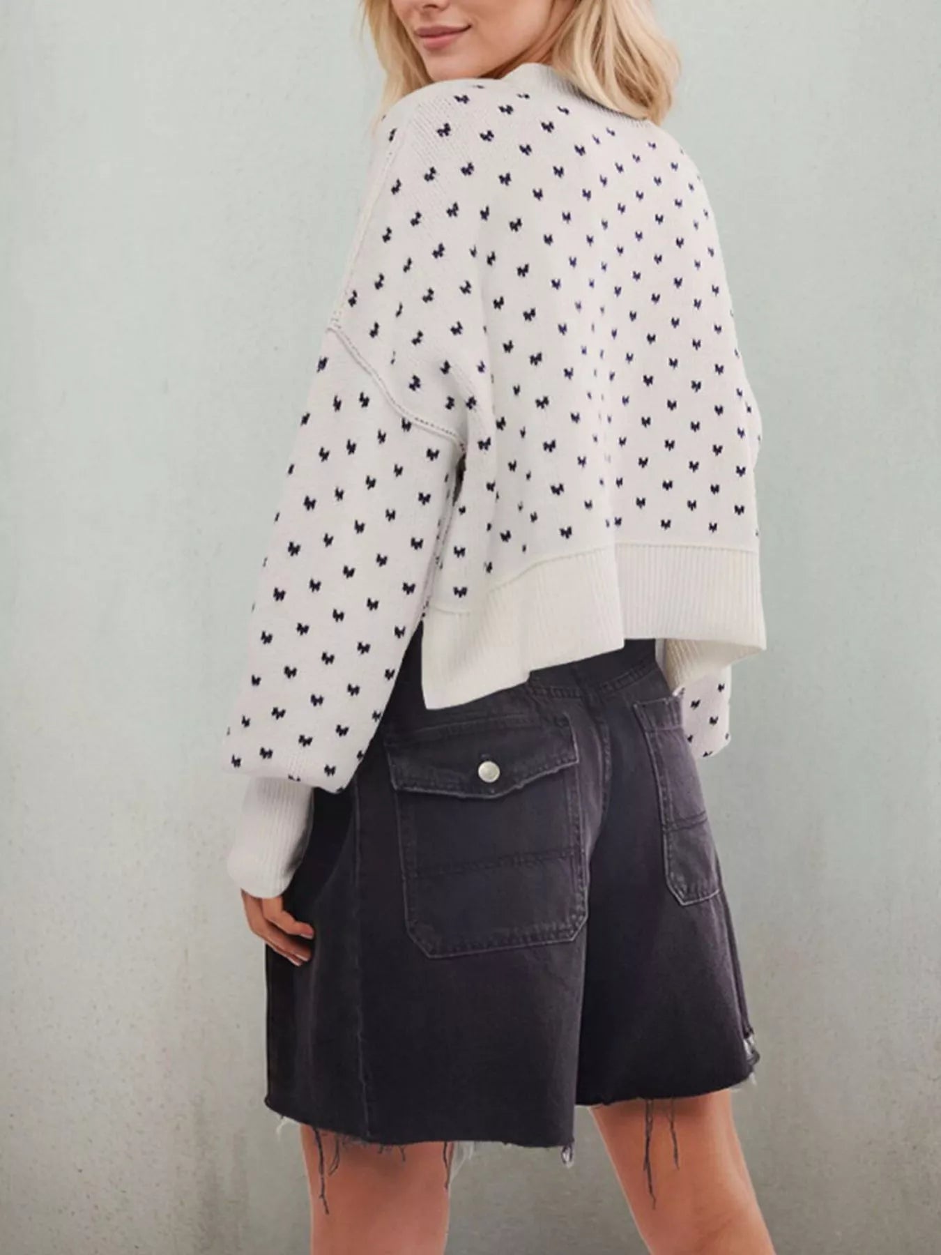 Back view of the white bow print sweater with dropped shoulders and ribbed hem