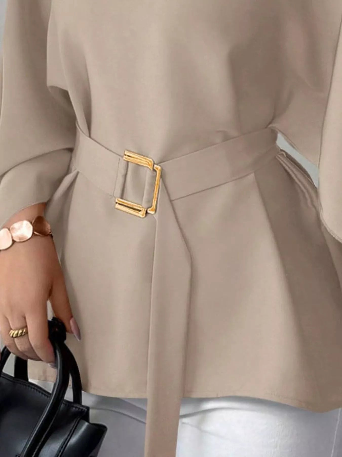 Close detail of khaki batwing sleeve blouse gold buckle belt and flared hem