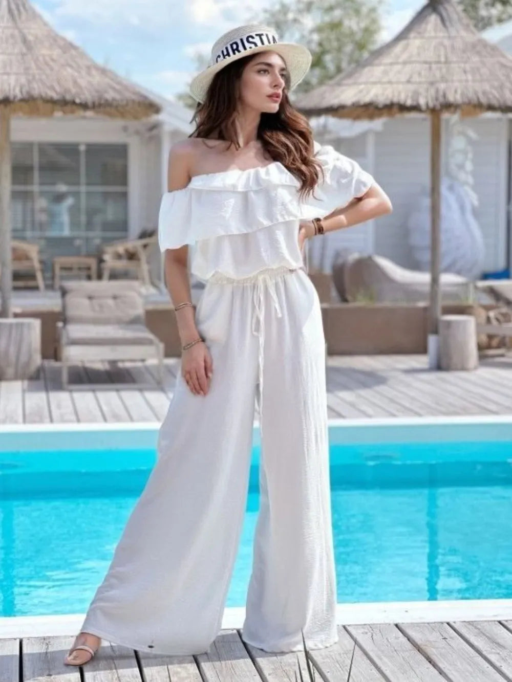 Women's off-shoulder jumpsuit with ruffled detailing and wide legs.