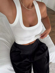 Close-up lifestyle view of a white ribbed tank top with wide straps and a scoop neckline