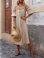 Women's tan off-shoulder midi dress with ruffled neckline and puff sleeves, front view on model holding a straw hat.