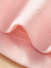 Close-up of the stitched hem and soft blush pink fabric on the children's tee