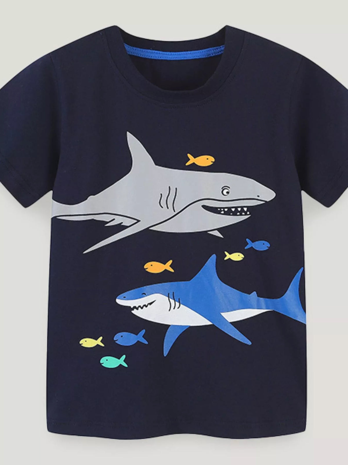 Front view of the black children's short sleeve t-shirt with gray and blue shark prints and small colorful fish