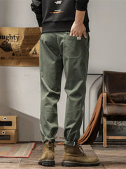 Men's slim fit casual pants with banded ankles and pockets.