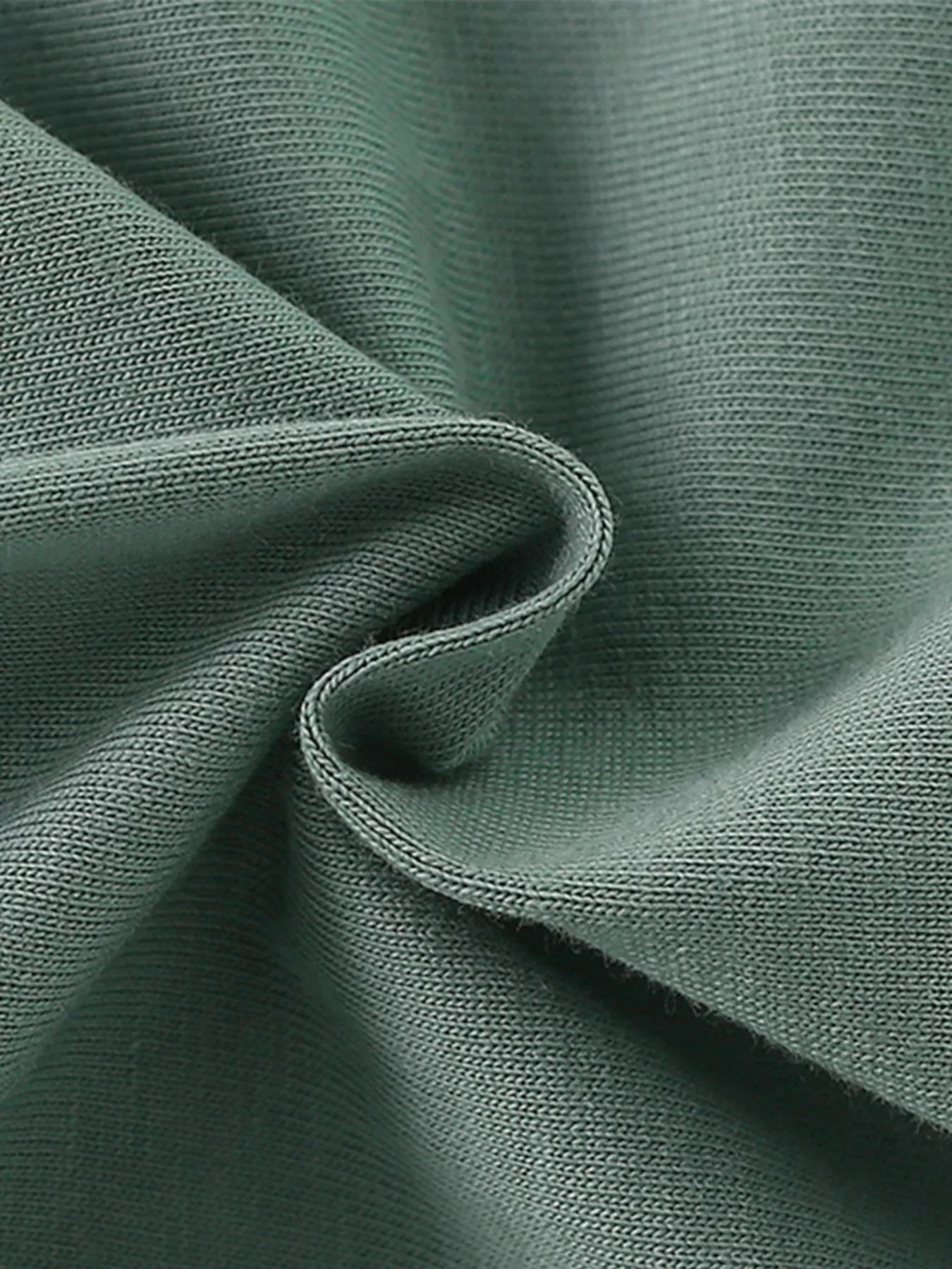 Close-up texture of the soft sage fabric of the children's short sleeve shirt