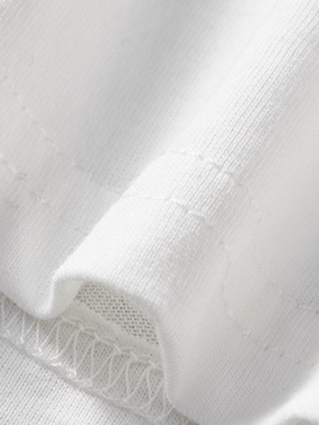 Close-up of the white fabric and hem stitching detail on a children's casual T-shirt