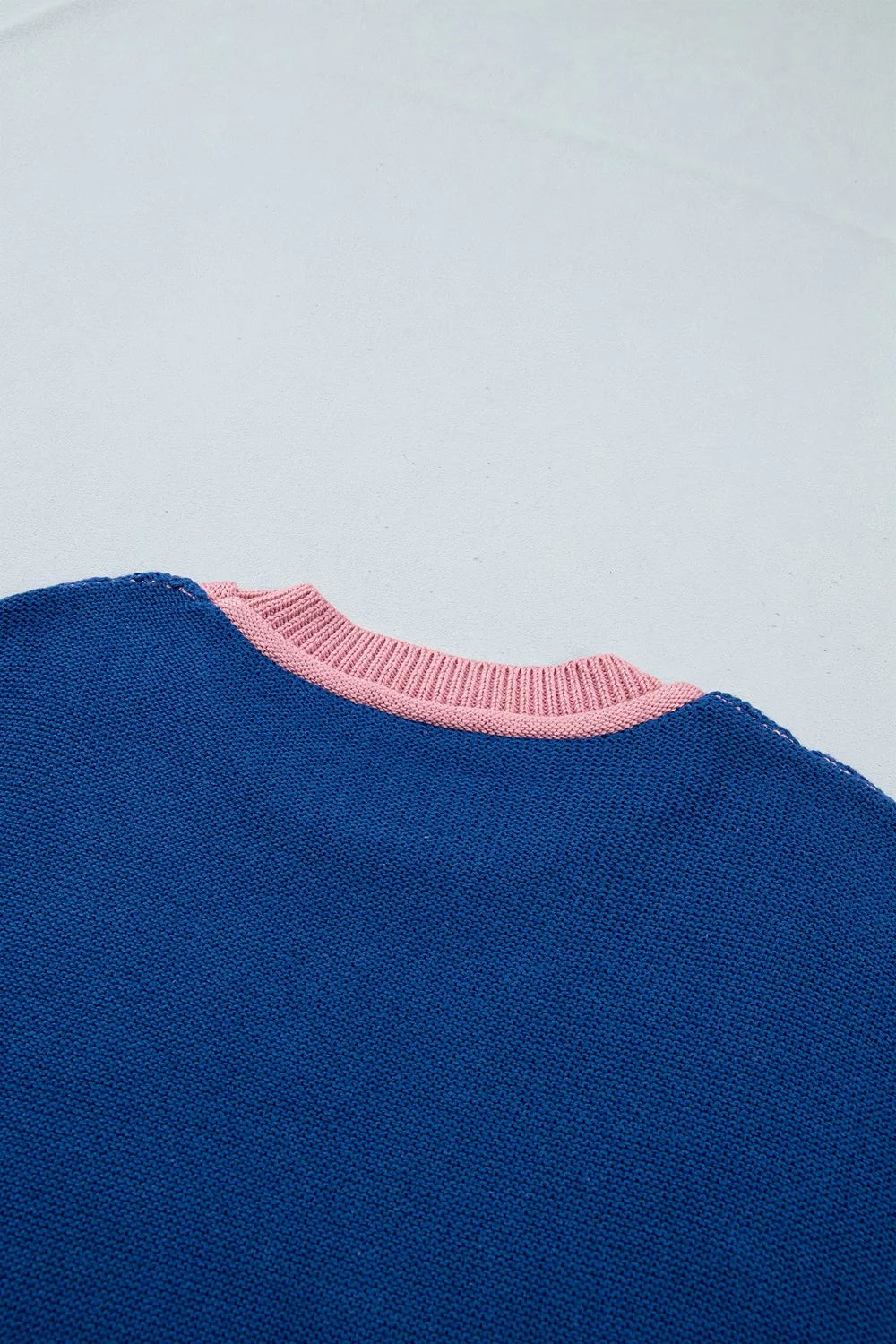 Close up of the blue sweater back neckline with a pink ribbed collar