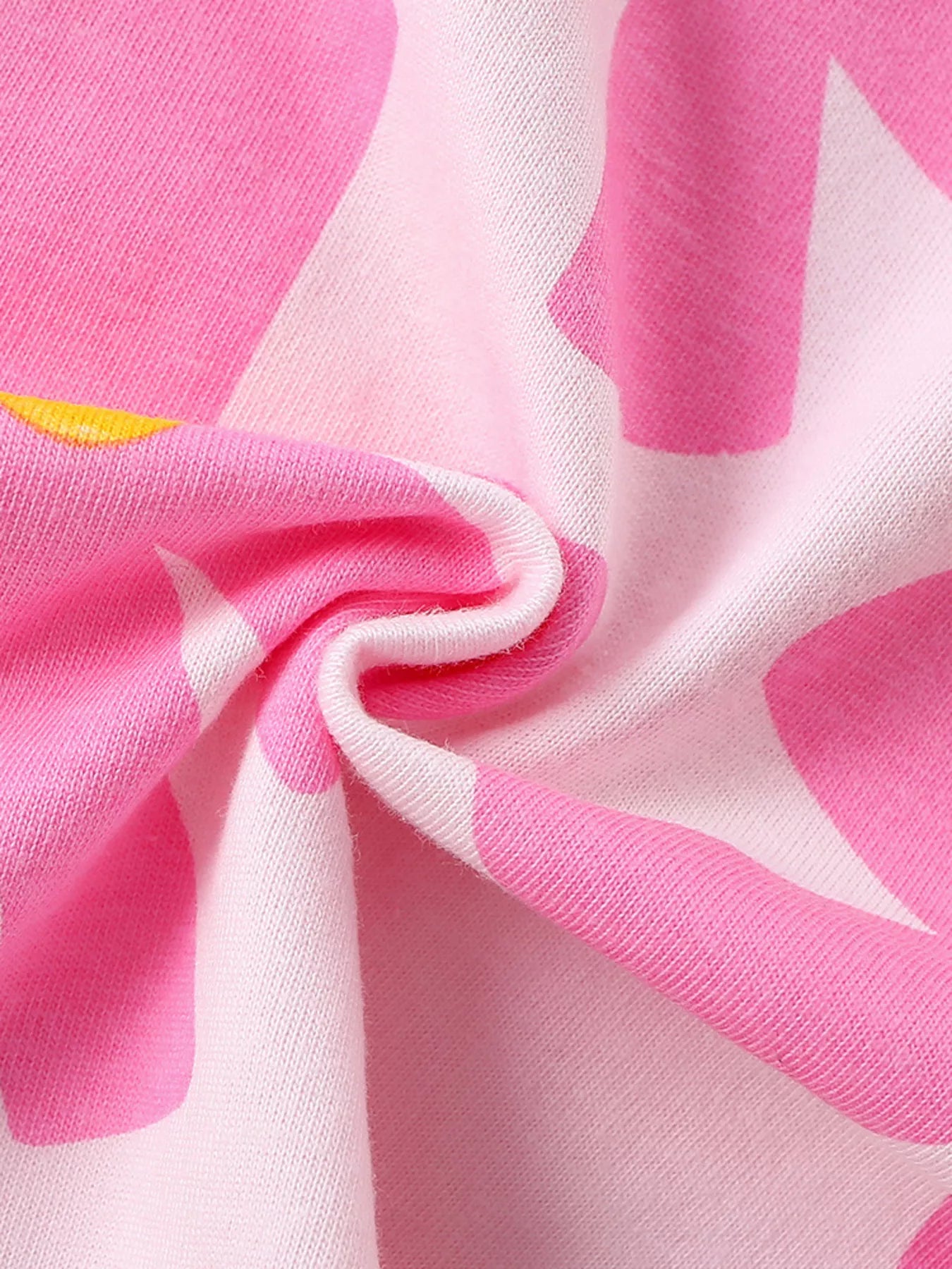 Close-up of twisted pink floral cotton fabric showing the children's t-shirt texture
