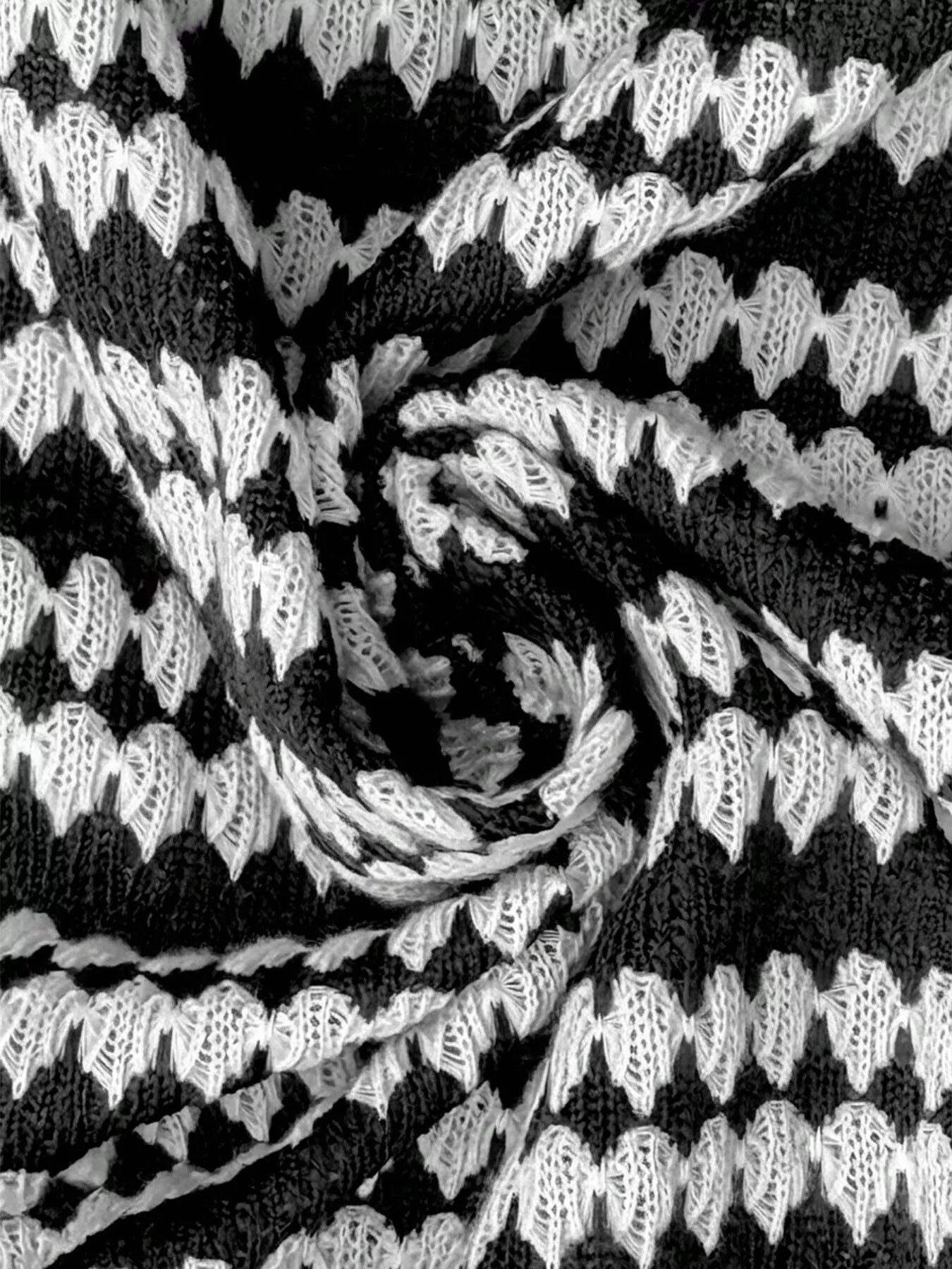 Extreme close-up of the black and white striped knit texture of the sweater dress fabric