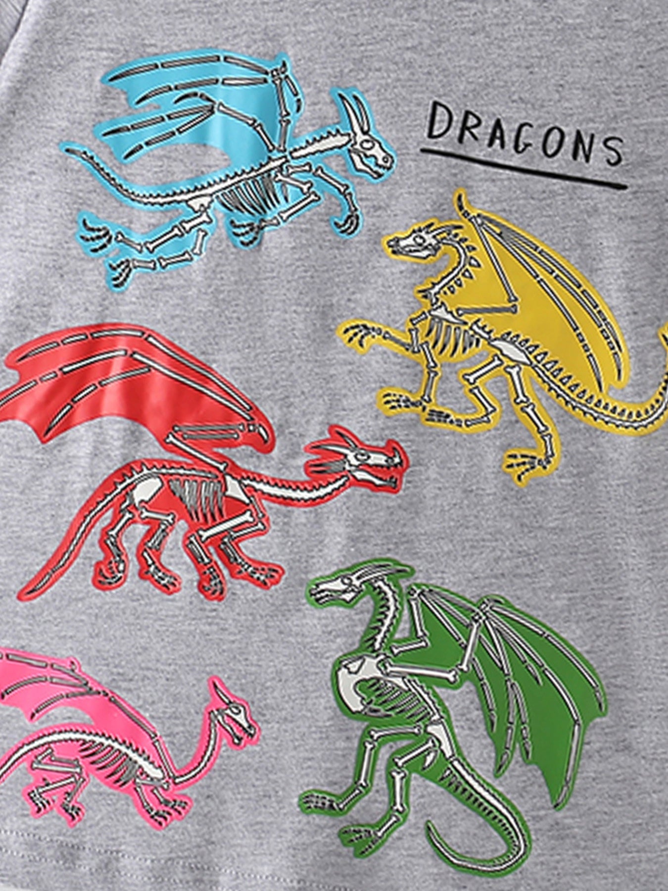 Close-up of the colorful blue, yellow, red, green and pink dragon skeleton prints on a gray children's T-shirt