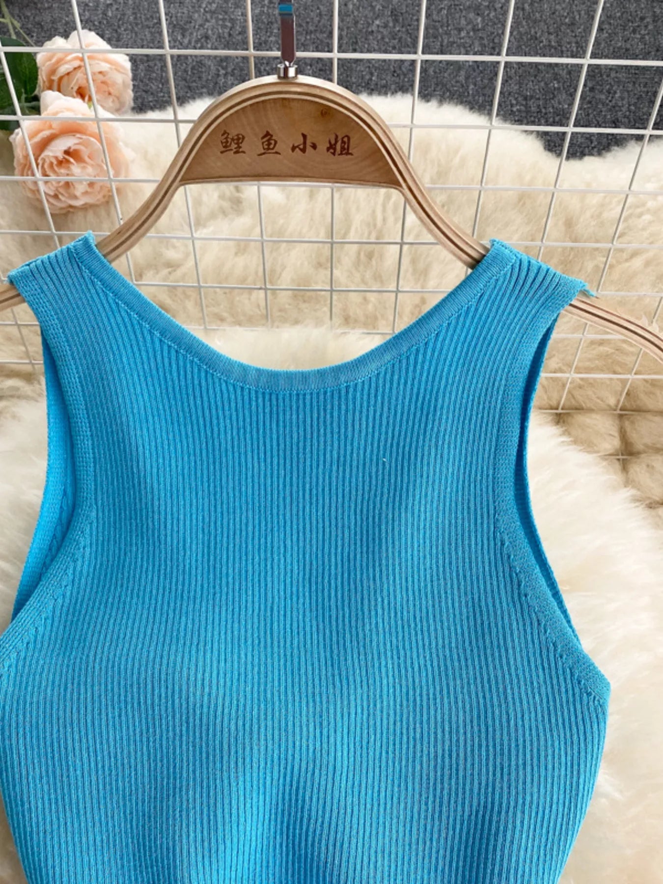 Close view of bright blue ribbed knit bodice with scoop neckline on hanger