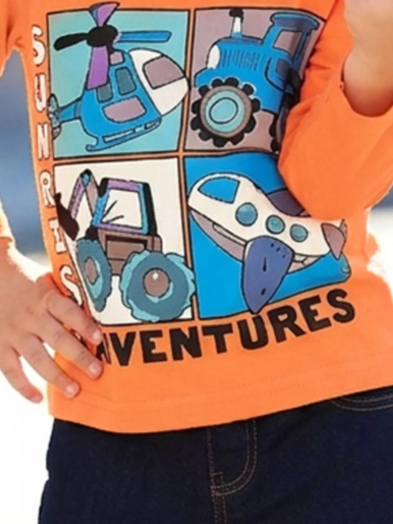 Angled close up of the vehicle graphic on a children's orange long sleeve tee