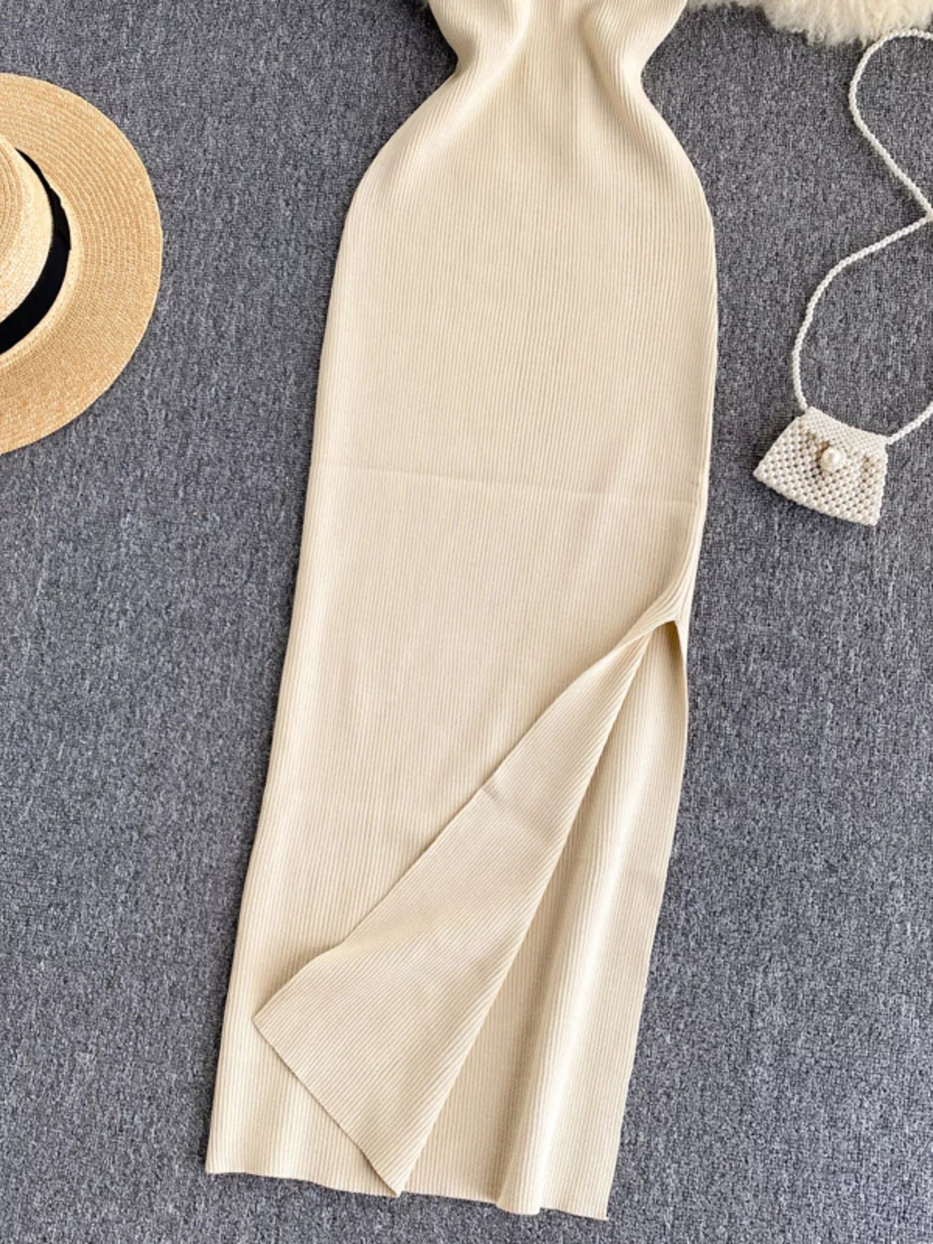 Lower skirt of cream white ribbed knit midi dress showing side slit detail