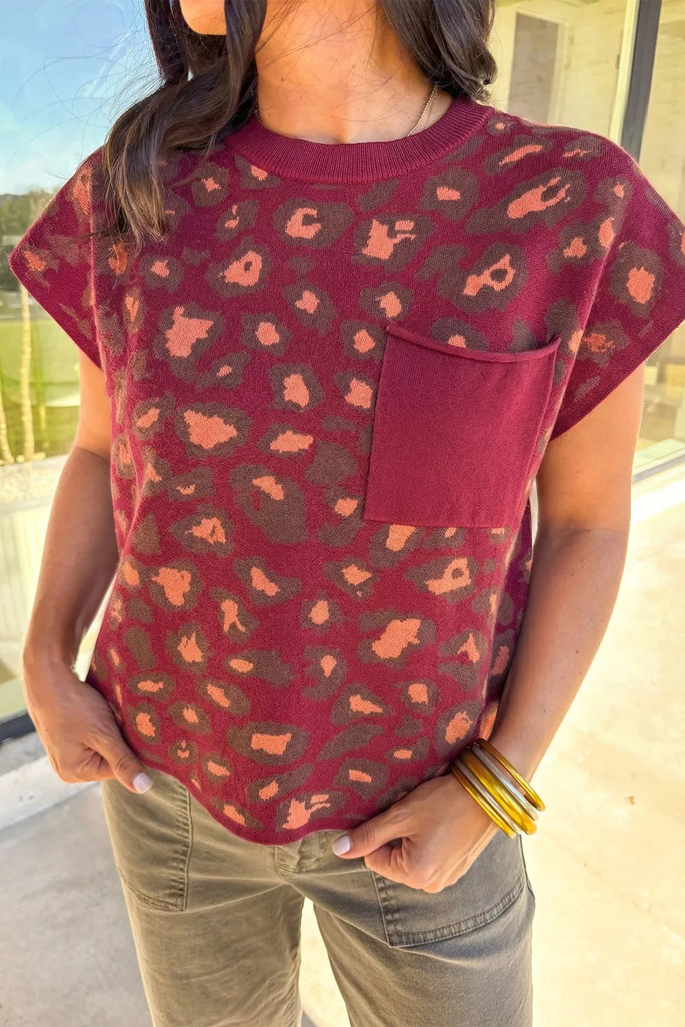 Front view of a deep red leopard print cap sleeve knit top with a chest pocket