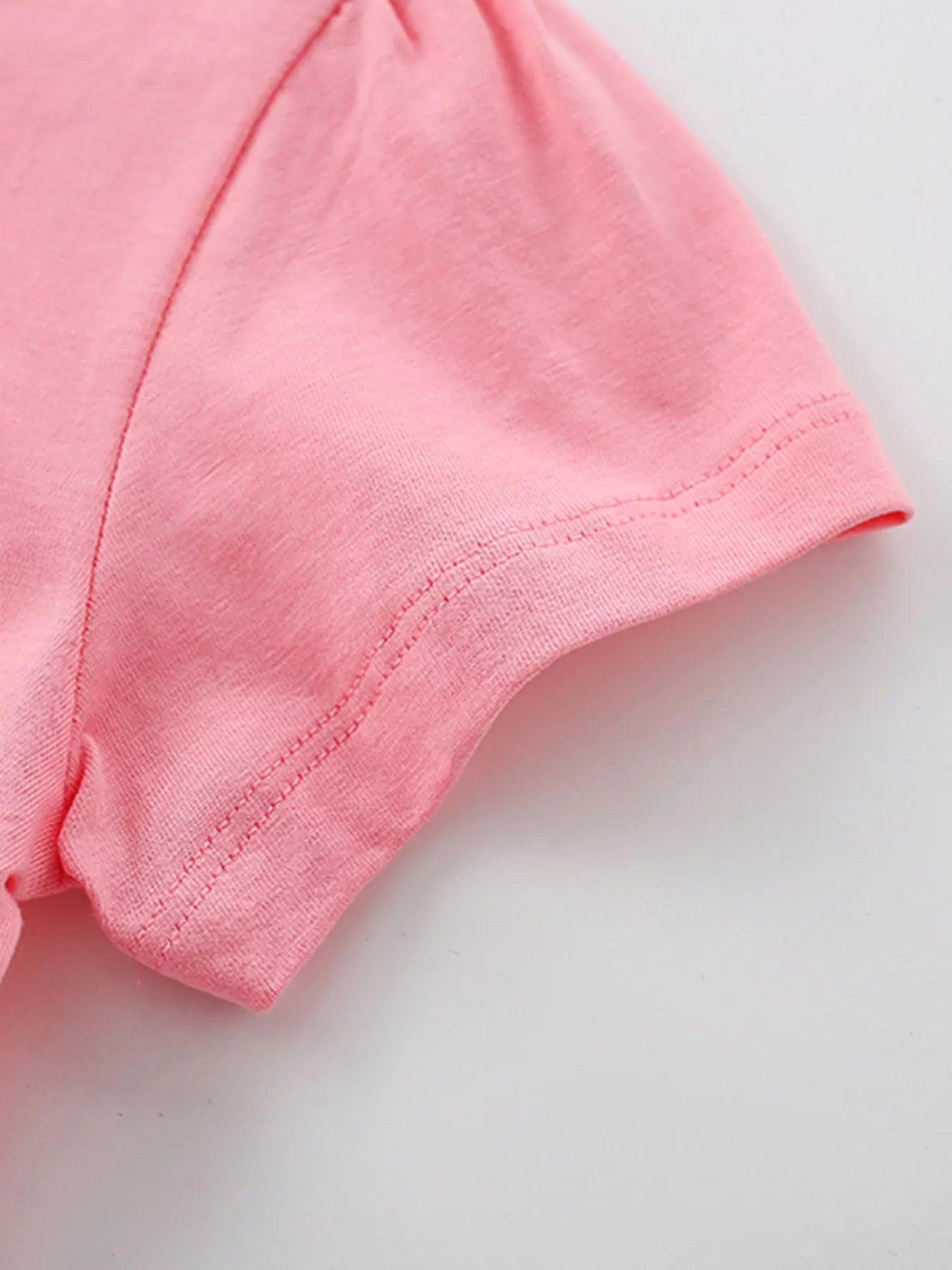 Close view of the short puff sleeve hem and stitching on the blush pink children's T-shirt