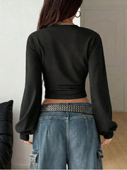 Back view of black long sleeve cropped t shirt with wide sleeves and jeans