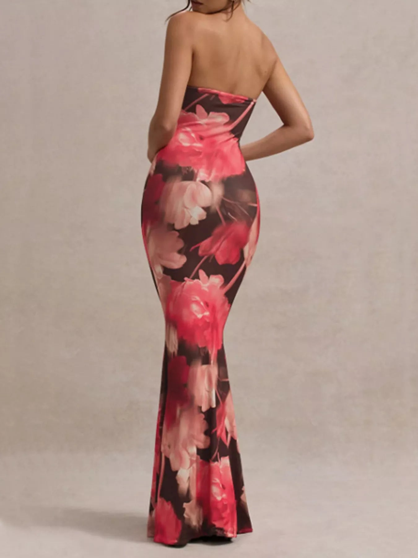 Model wearing strapless dark brown and red floral tube maxi dress, back view in studio