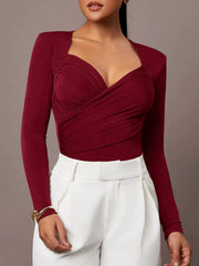 Burgundy ruched surplice long sleeve bodysuit styled with white trousers, front view