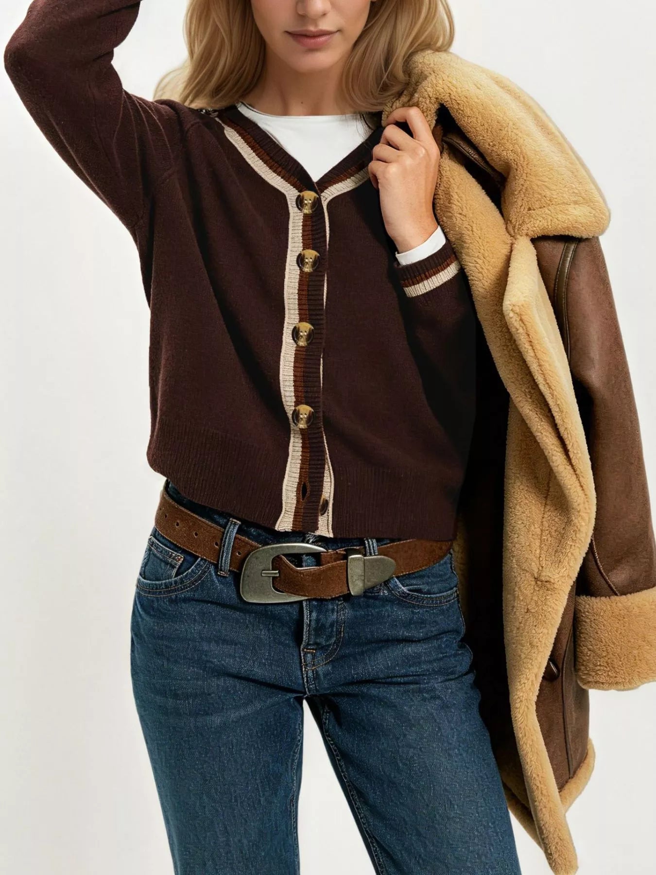 On-model front view of brown button down cardigan with cream and brown striped trim layered over white top