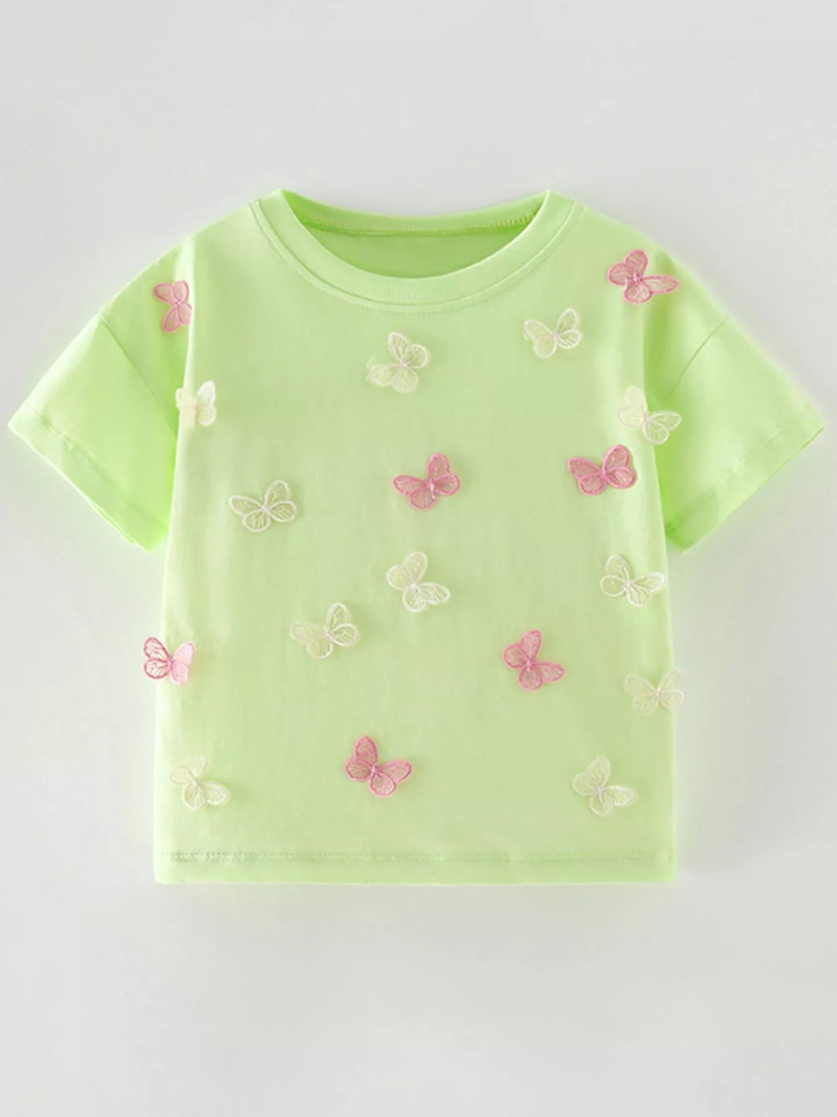 Flat front view of a light green children's tee scattered with pink and white butterfly appliques