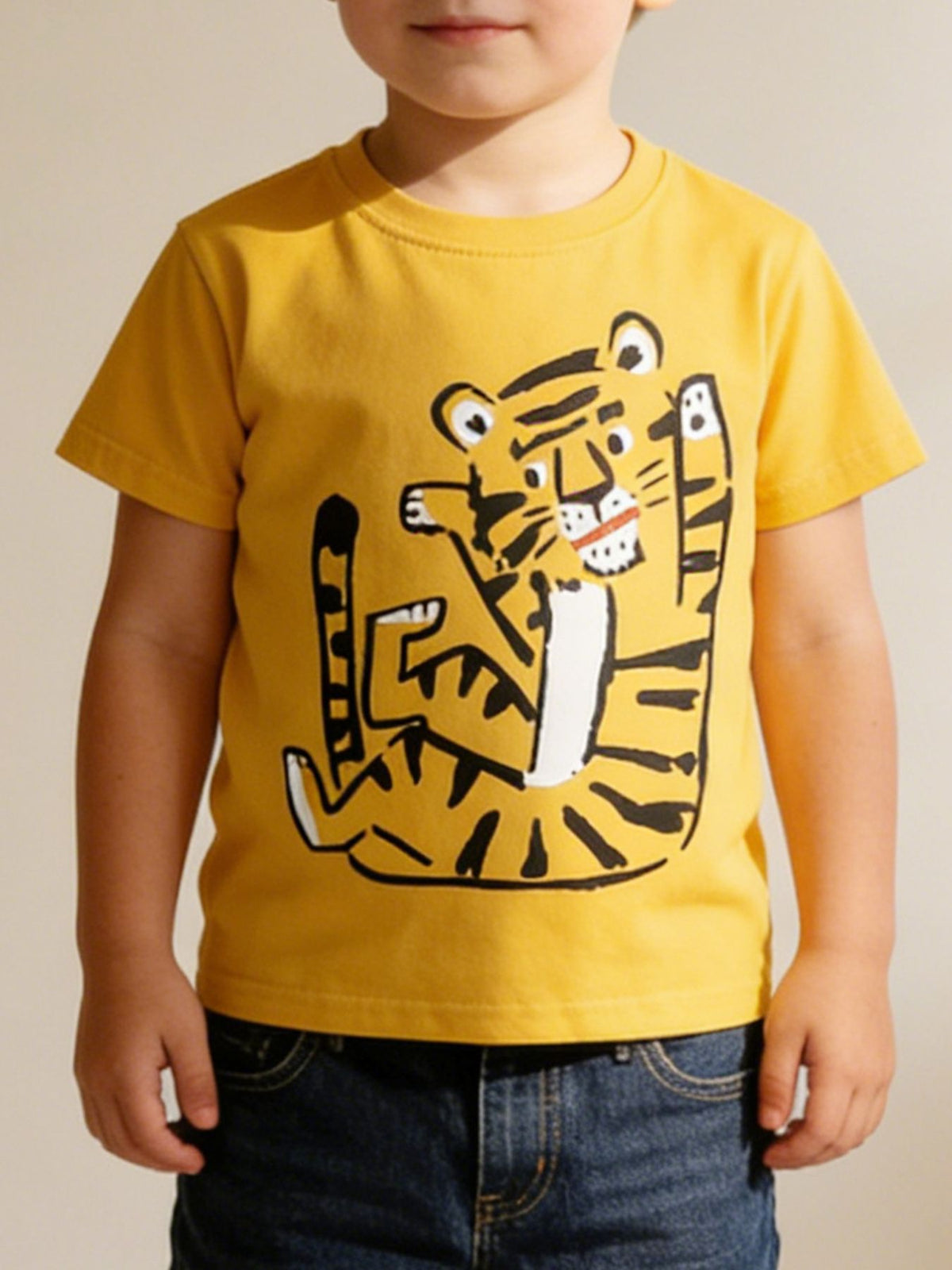 Children's mustard round neck t-shirt worn in front view with playful cartoon tiger graphic