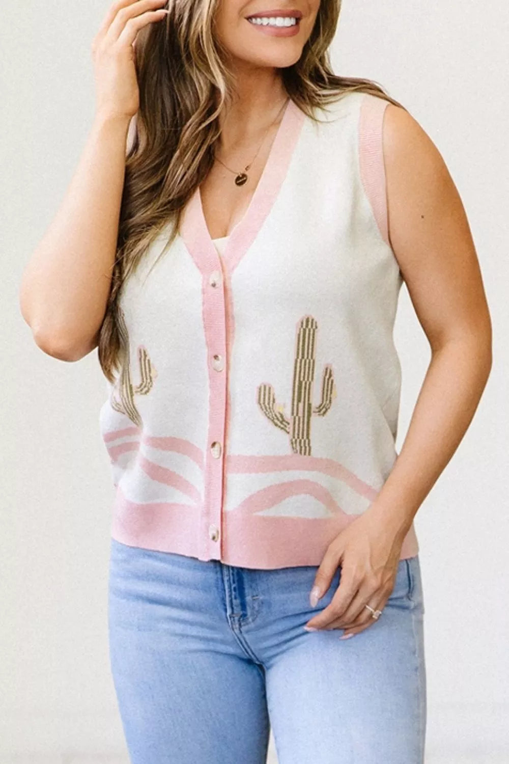 On-model front view of the cream cactus sweater vest buttoned over a white top
