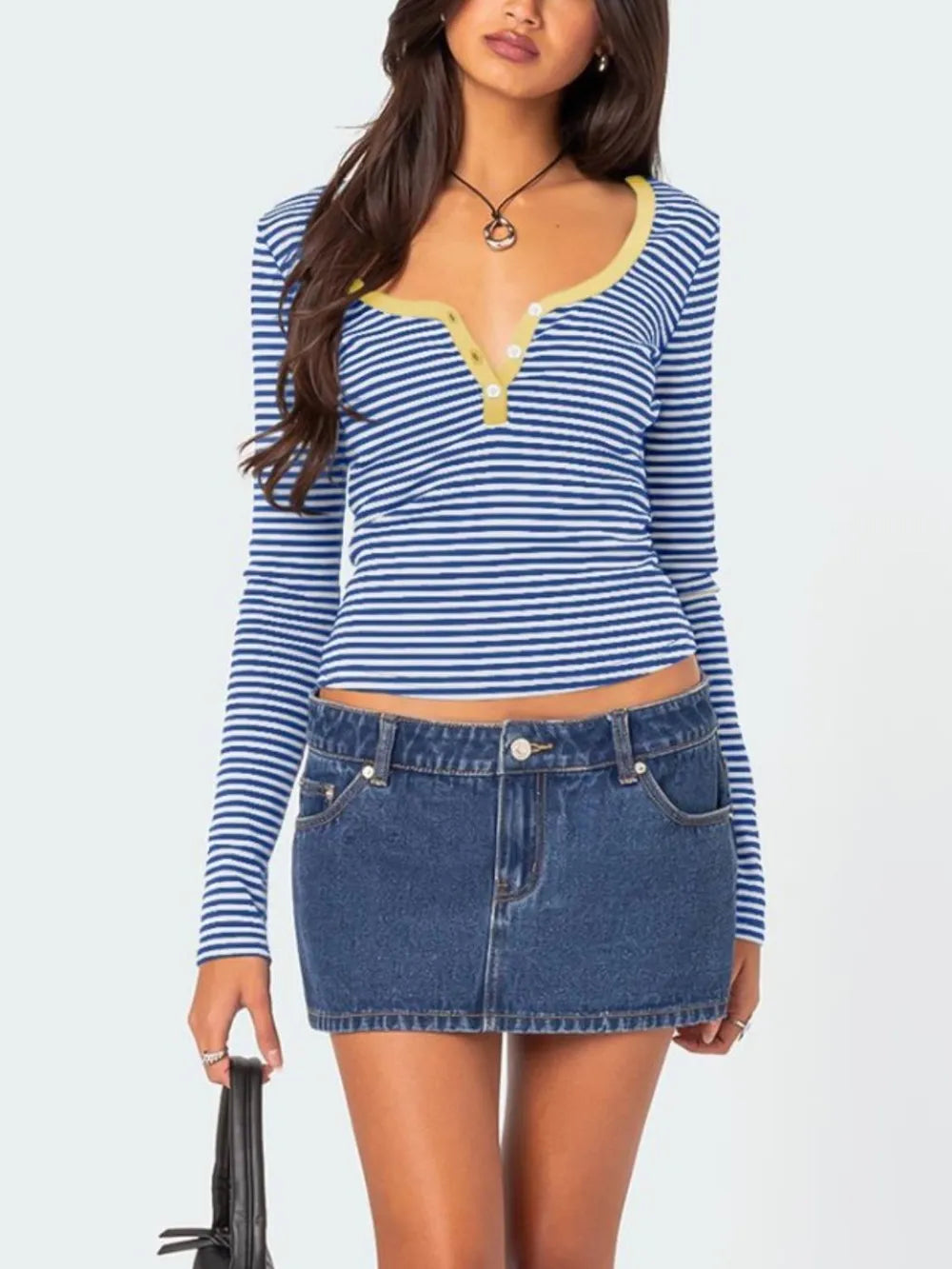 Front view of royal blue and white striped long sleeve t shirt with pale yellow trim worn with denim skirt