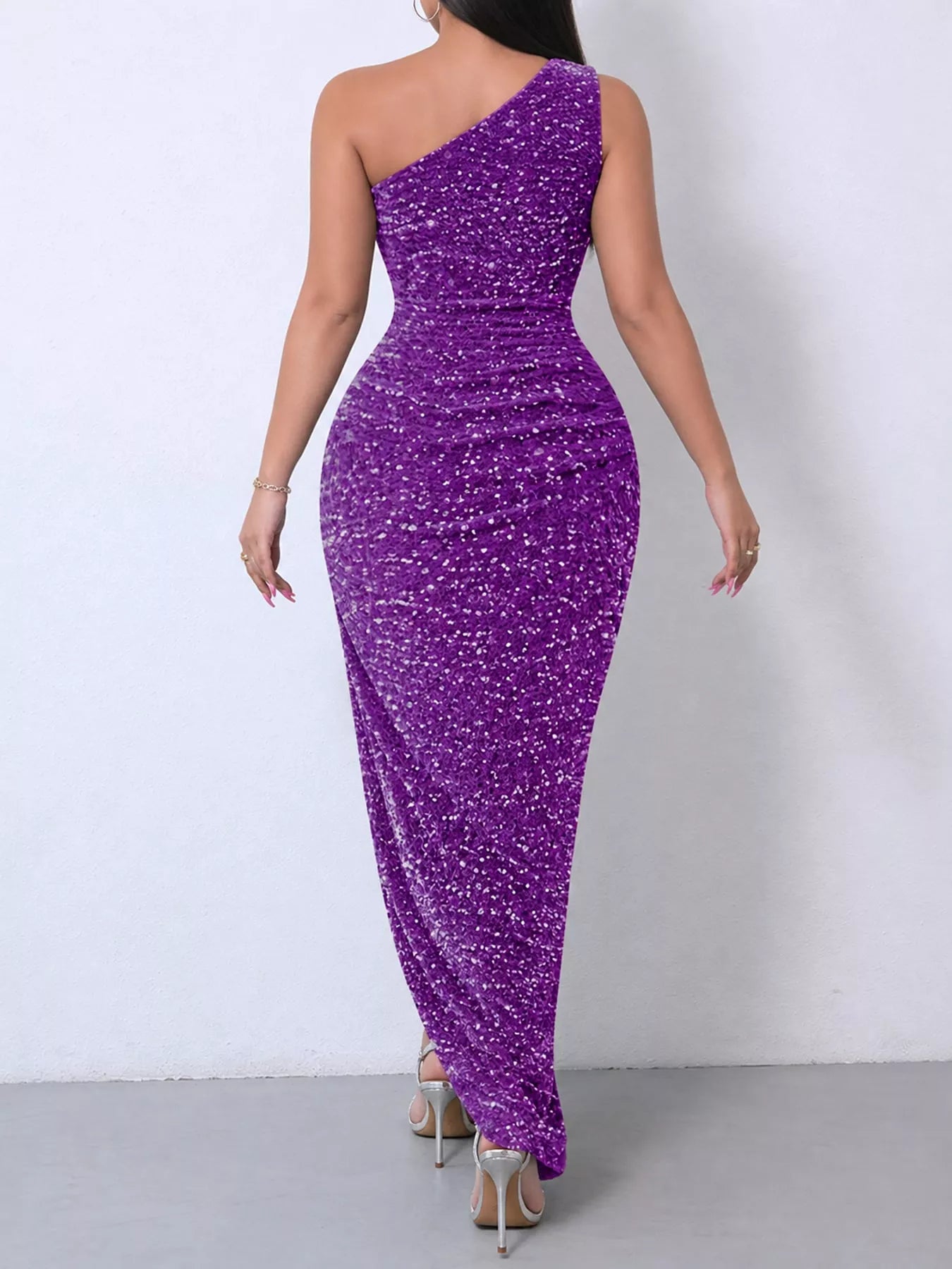 Purple sequin one shoulder evening dress worn from the back showing the ruched bodice